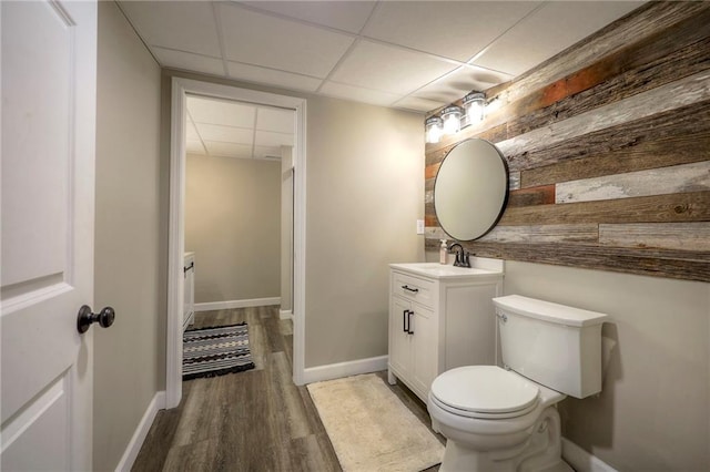 43 901st Rd, Clinton, MO 64735 - half bath with vanity, baseboards, toilet, a drop ceiling, and wood finished floors