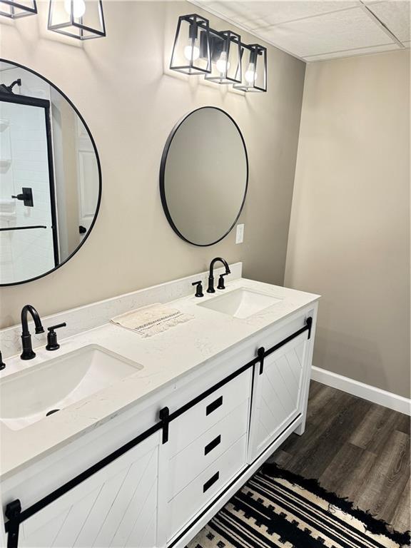 43 901st Rd, Clinton, MO 64735 - bathroom with wood finished floors, double vanity, a sink, and baseboards