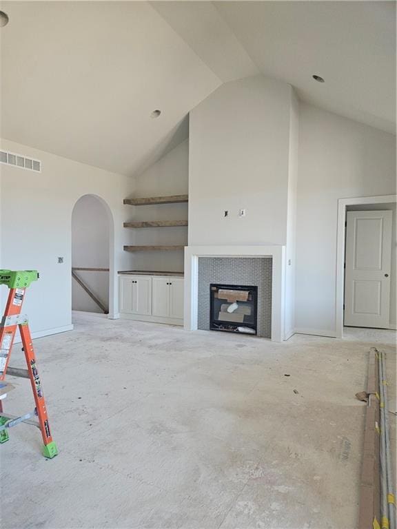 4967 146th St, Basehor, KS 66007 - unfurnished living room featuring high vaulted ceiling, a fireplace, arched walkways, and baseboards