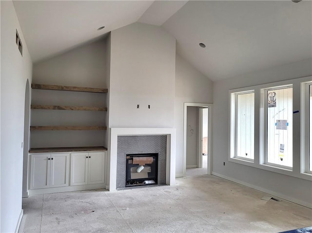 4967 146th St, Basehor, KS 66007 - unfurnished living room featuring baseboards, high vaulted ceiling, and a tile fireplace