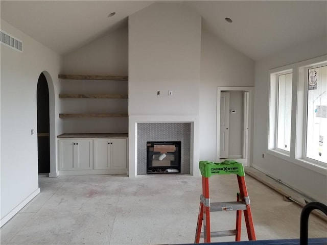4967 146th St, Basehor, KS 66007 - living room featuring high vaulted ceiling, arched walkways, baseboards, and a tile fireplace