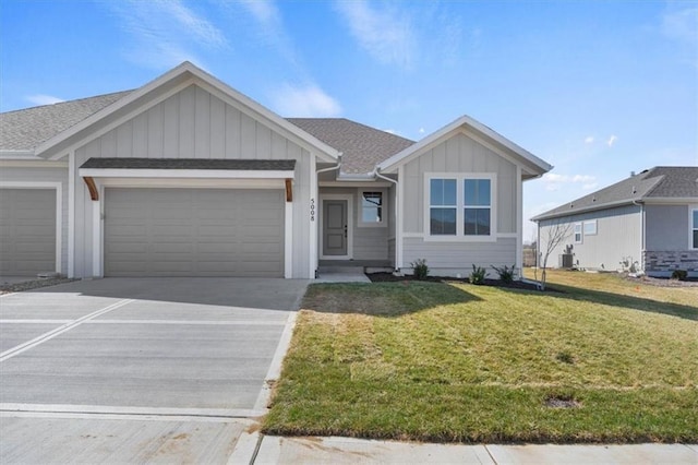 4967 146th St, Basehor, KS 66007 - view of front of home featuring board and batten siding, a garage, concrete driveway, a front lawn, and central AC