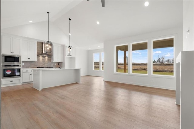 4967 146th St, Basehor, KS 66007 - kitchen featuring stainless steel appliances, wall chimney exhaust hood, beamed ceiling, tasteful backsplash, and light wood-type flooring