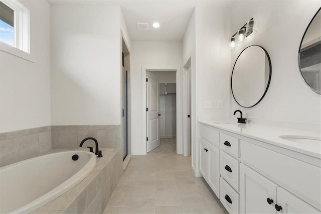 4967 146th St, Basehor, KS 66007 - bathroom with a bath, double vanity, a spacious closet, a stall shower, and tile patterned floors