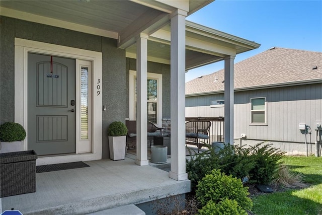 309 NE 102nd Ter, Kansas City, MO 64155 - property entrance with stucco siding, a shingled roof, and covered porch