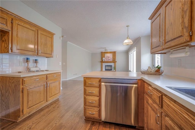 kitchen featuring dishwasher, decorative backsplash, light countertops, a ceiling fan, and a textured ceiling