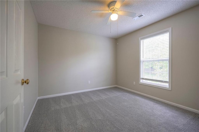 unfurnished room featuring a textured ceiling, carpet, a ceiling fan, and baseboards