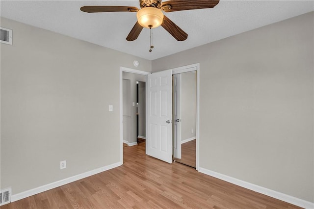 2411 NE 60th St, Gladstone, MO 64118 - unfurnished bedroom with light wood-type flooring, baseboards, visible vents, a ceiling fan, and a closet