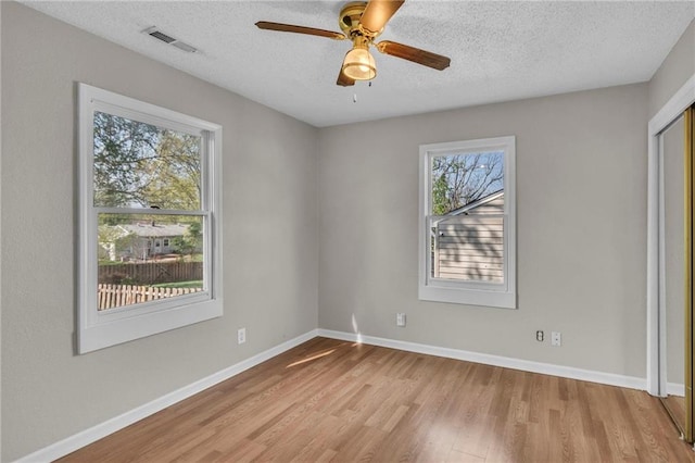 2411 NE 60th St, Gladstone, MO 64118 - spare room with light wood finished floors, a textured ceiling, baseboards, visible vents, and a ceiling fan