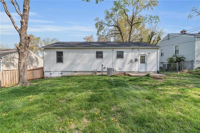 2411 NE 60th St, Gladstone, MO 64118 - rear view of property with a fenced backyard, central AC unit, and a yard