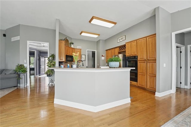 797 NW 1621st Rd, Bates City, MO 64011 - kitchen featuring visible vents, open floor plan, light countertops, light wood finished floors, and black appliances
