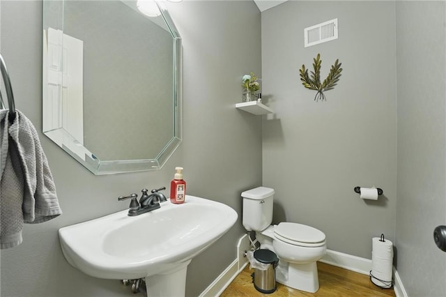 797 NW 1621st Rd, Bates City, MO 64011 - bathroom featuring visible vents, wood finished floors, a sink, baseboards, and toilet