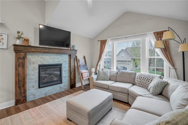 12631 Fountain Lake Cir, Grandview, MO 64030 - living room featuring vaulted ceiling, a fireplace, and wood finished floors