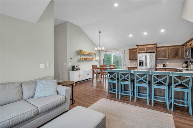 12631 Fountain Lake Cir, Grandview, MO 64030 - living room featuring a chandelier, lofted ceiling, wood finished floors, and recessed lighting