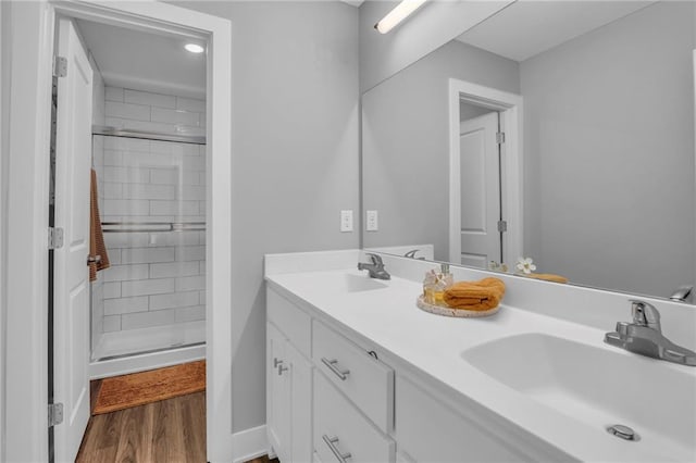 12631 Fountain Lake Cir, Grandview, MO 64030 - full bathroom with a stall shower, double vanity, and wood finished floors