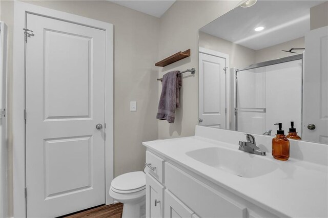 12631 Fountain Lake Cir, Grandview, MO 64030 - bathroom with vanity, a shower with shower door, wood finished floors, and recessed lighting