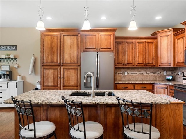 105 Fox Den Ct, Savannah, MO 64485 - kitchen featuring stainless steel fridge, range with electric stovetop, a sink, brown cabinets, and dark wood-type flooring