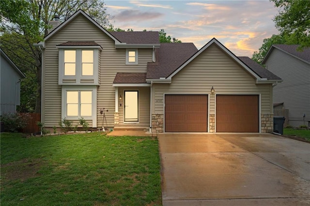 traditional home with a garage, a chimney, a shingled roof, concrete driveway, and a lawn