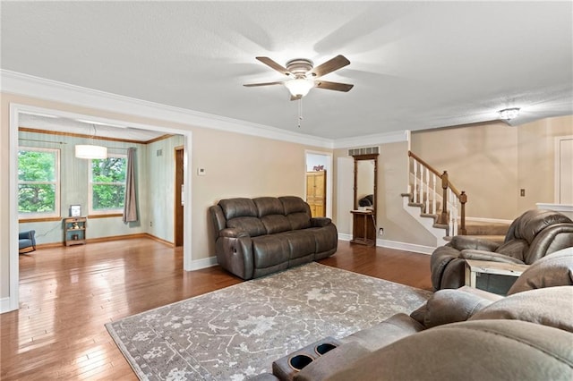 living area featuring stairway, ornamental molding, hardwood / wood-style flooring, and ceiling fan