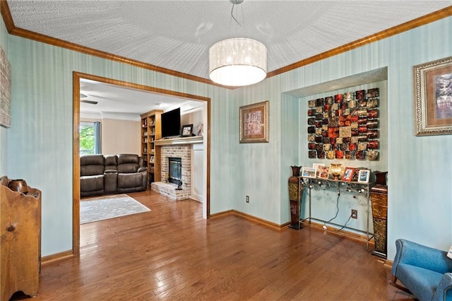 dining space with crown molding, baseboards, a brick fireplace, and hardwood / wood-style flooring
