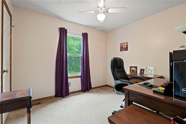 office space featuring ceiling fan, a textured ceiling, visible vents, light colored carpet, and baseboards