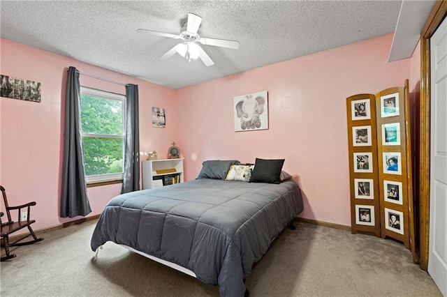 bedroom featuring baseboards, a textured ceiling, carpet, and a ceiling fan