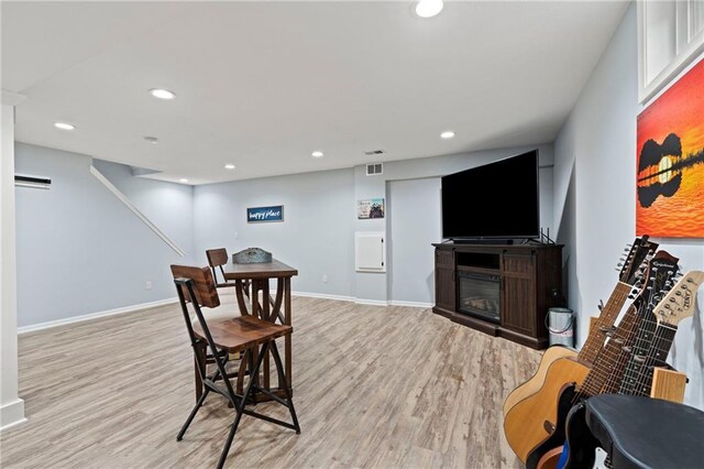 dining room with visible vents, a glass covered fireplace, light wood-style floors, baseboards, and recessed lighting