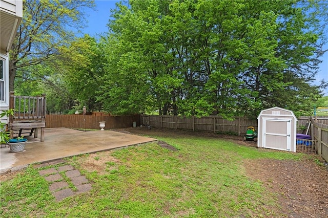 view of yard with a fenced backyard, a storage unit, an outbuilding, and a patio area