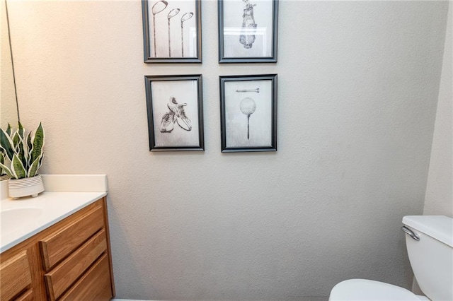 half bathroom featuring vanity and toilet