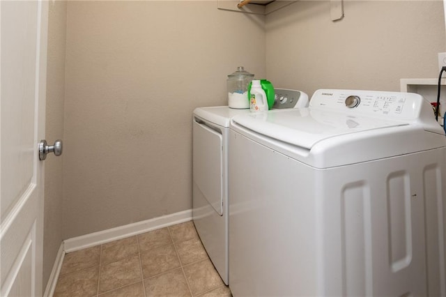 laundry room with separate washer and dryer, baseboards, light tile patterned flooring, and laundry area