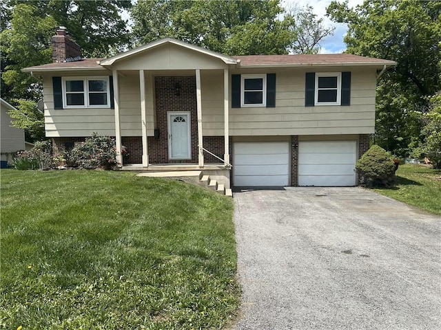 83 Grandview Dr, Warrensburg, MO 64093 - split foyer home featuring a garage, brick siding, a chimney, a front lawn, and driveway