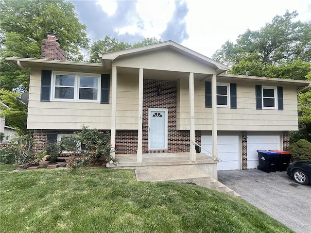 83 Grandview Dr, Warrensburg, MO 64093 - raised ranch with brick siding, a garage, a chimney, asphalt driveway, and a front lawn
