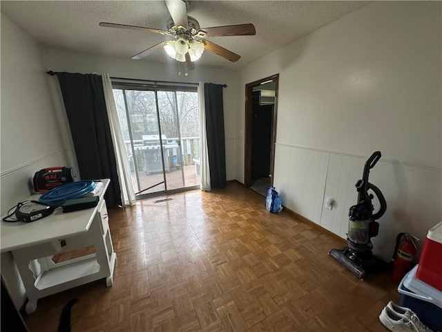 83 Grandview Dr, Warrensburg, MO 64093 - interior space featuring a textured ceiling, a ceiling fan, and a wainscoted wall