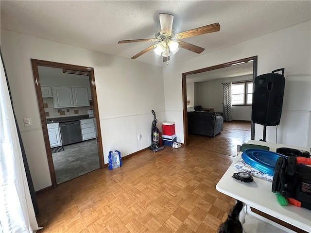 83 Grandview Dr, Warrensburg, MO 64093 - dining space with a ceiling fan, baseboards, a wainscoted wall, and a textured ceiling