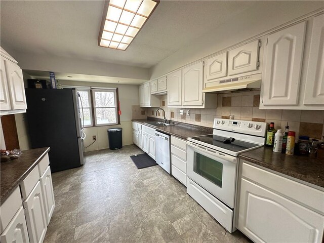 83 Grandview Dr, Warrensburg, MO 64093 - kitchen featuring appliances with stainless steel finishes, under cabinet range hood, a sink, dark countertops, and white cabinets