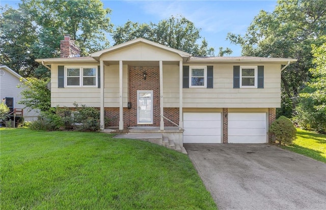 83 Grandview Dr, Warrensburg, MO 64093 - split foyer home featuring brick siding, a chimney, a front yard, driveway, and a garage
