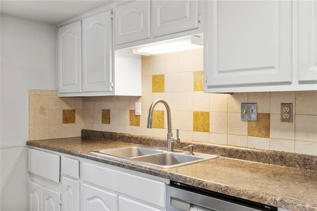 83 Grandview Dr, Warrensburg, MO 64093 - kitchen with stainless steel dishwasher, white cabinetry, dark countertops, and decorative backsplash