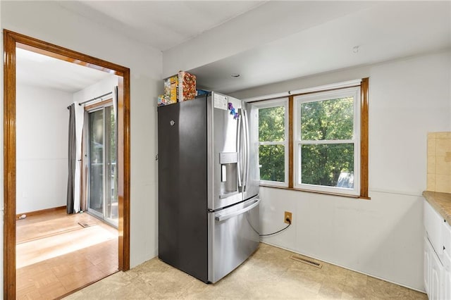 83 Grandview Dr, Warrensburg, MO 64093 - kitchen featuring stainless steel fridge with ice dispenser, white cabinets, light countertops, and light flooring