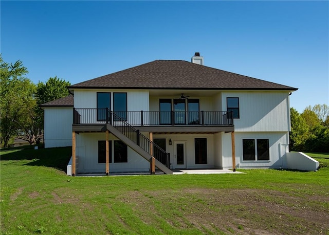 rear view of property featuring a ceiling fan, a chimney, a lawn, stairs, and a patio area