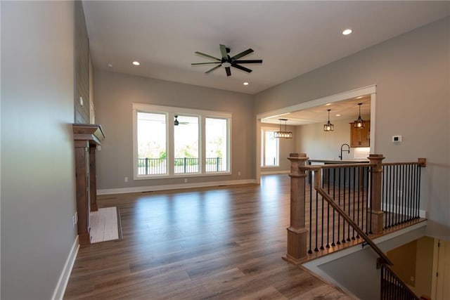 unfurnished living room with dark wood-type flooring, baseboards, a ceiling fan, and recessed lighting