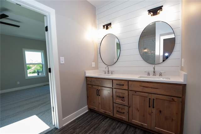 bathroom featuring double vanity, baseboards, and a sink