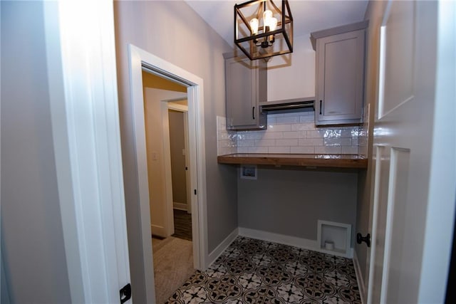 laundry area with cabinet space, baseboards, a notable chandelier, and hookup for a washing machine