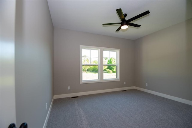 carpeted spare room featuring ceiling fan, baseboards, and visible vents