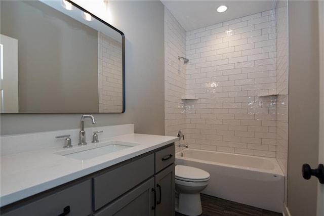 full bathroom with recessed lighting, toilet,  shower combination, vanity, and wood finished floors
