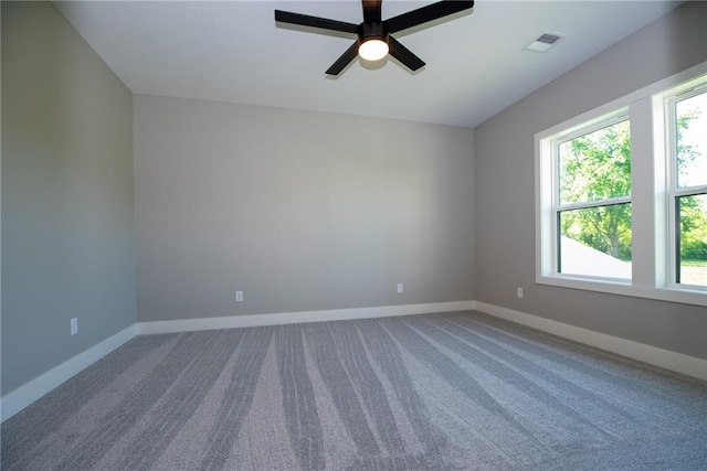 carpeted empty room with visible vents, baseboards, and ceiling fan