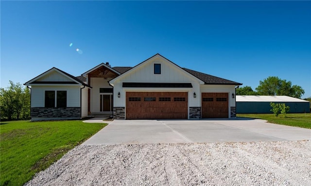 view of front of home with an attached garage, stone siding, concrete driveway, board and batten siding, and a front yard