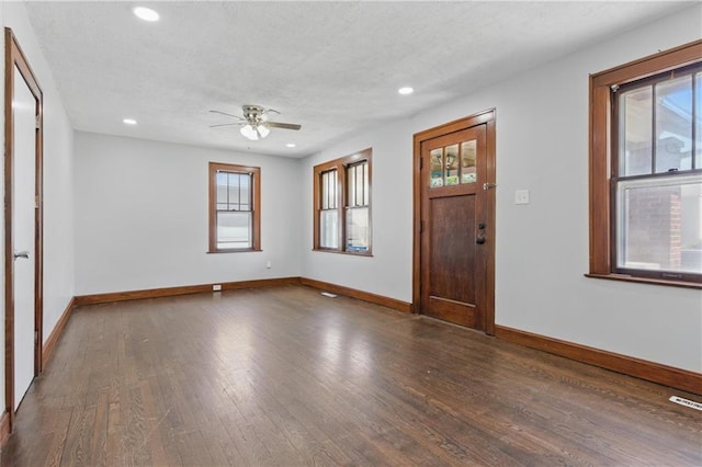 entryway featuring wood finished floors, baseboards, ceiling fan, and a healthy amount of sunlight