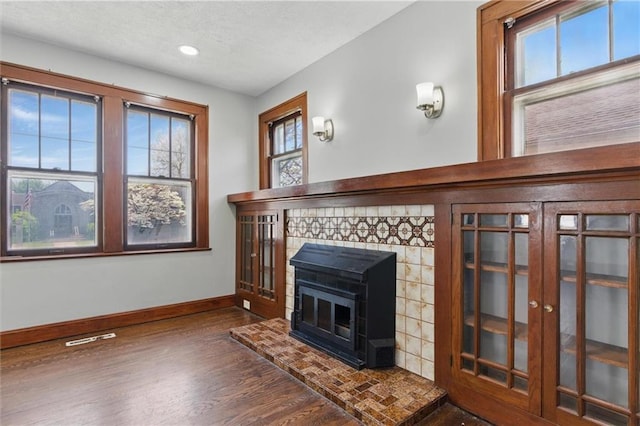 unfurnished living room featuring wood finished floors, a textured ceiling, baseboards, visible vents, and recessed lighting