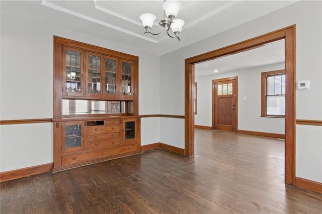 interior space with baseboards, wood finished floors, and a chandelier