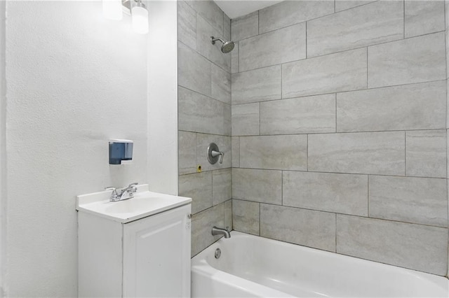 bathroom featuring shower / washtub combination, vanity, and a textured wall